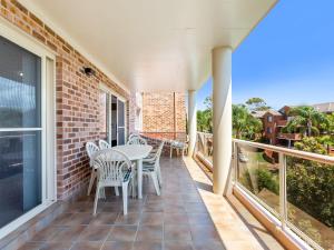 a patio with a table and chairs on a balcony at Cottage Court 4 Shoal Bay and Little Beach at your fingertips in Nelson Bay