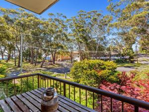 a bench on a balcony with a view of a park at Magnus Gardens 4 beautiful air conditioned unit with filtered water views and Wi-Fi in Nelson Bay
