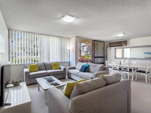 a living room with couches and a dining room at Magnus Gardens 4 beautiful air conditioned unit with filtered water views and Wi-Fi in Nelson Bay