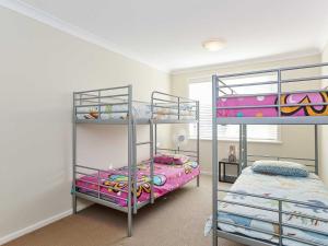 een slaapkamer met 2 stapelbedden en een bed bij Tomaree Townhouse 5 large air conditioned townhouse and WI-FI in Nelson Bay