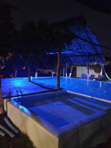 una piscina con iluminación azul por la noche en Mi Casa en la Playa, en Escuintla