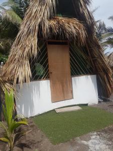 a house with a thatched roof with a door at Mi Casa en la Playa in El Paredón Buena Vista +25 photos
