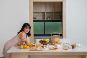 a woman standing in front of a table with food at Dhevan Dara Resort & Spa Hua Hin - Pool Villa in Hua Hin