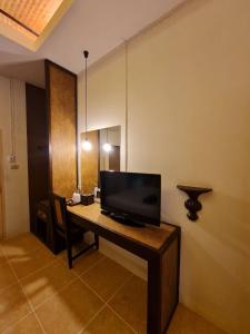 Habitación con escritorio y TV. en Sleep CNX, en Chiang Mai