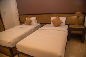two beds in a hotel room with pillows at Sleep CNX in Chiang Mai
