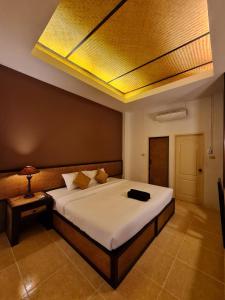 a bedroom with a large bed with a yellow ceiling at Sleep CNX in Chiang Mai