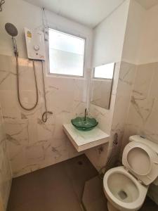 a bathroom with a shower and a toilet and a sink at Sleep CNX in Chiang Mai