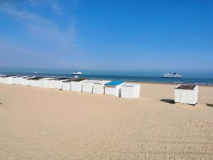 a row of beach huts on a sandy beach at Au Kaycedra in Calais