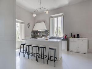 uma cozinha com uma ilha branca com bancos de bar em Belvilla by OYO Villa Rose em Cecina