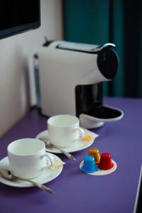 two cups and saucers sitting on a purple table at City Hotel Shymkent in Shymkent