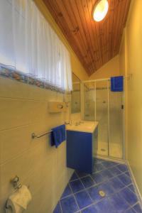 a bathroom with a shower and a sink and a toilet at Sunlover Lodge in Kinka