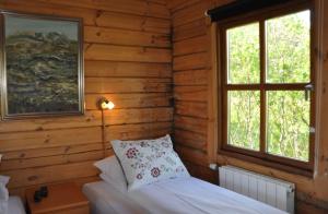 una camera con un letto in una baita di tronchi di North Star Cottage a Eyvindarhólar