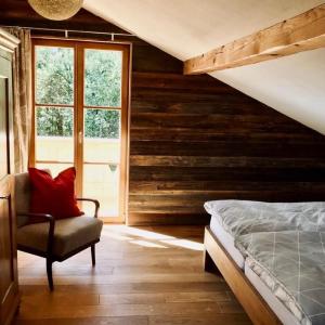 a bedroom with a bed and a chair and a window at Chalet Dürrfeld ***** in Viechtach