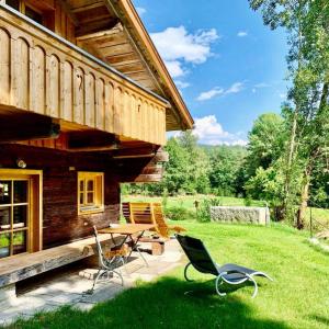 a log cabin with a table and chairs in the grass at Chalet Dürrfeld ***** in Viechtach