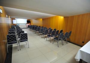 a row of chairs in a room with wooden walls at Hotel Premium Plaza in Muriaé