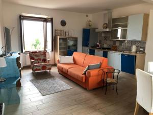 un soggiorno con divano arancione e una cucina di Appartamento Garibaldi a Orvieto