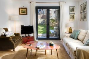 sala de estar con sofá y mesa de centro en La Borda del Pueyo borda rural pirineo aragonés, en El Pueyo de Jaca