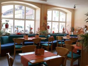 a restaurant with tables and chairs and windows at Stadtcafé Hotel garni in Hammelburg