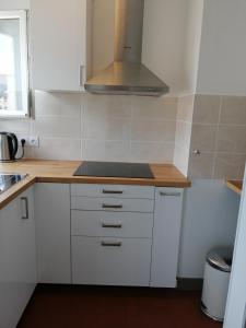 een keuken met witte kasten en een fornuis bij Ravissant studio proche de la Loire in Orléans