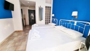 a bedroom with two beds and a blue wall at Casa Di Estella in Neos Marmaras +19 photos