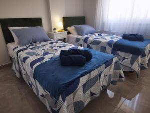 a room with two beds with blue and white sheets at Hawaii Holiday Apartment 41 in Limassol