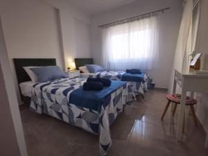 a bedroom with two beds and a window at Hawaii Holiday Apartment 41 in Limassol