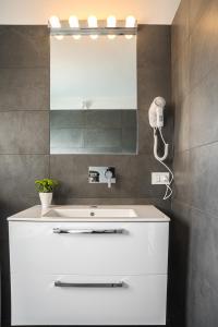 bagno con lavandino bianco e specchio di Apartments Florence - Pier Capponi Duomo a Firenze