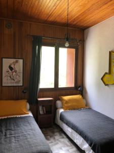 1 dormitorio con 2 camas y ventana en Pont de Frappe, en Chabottes