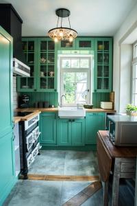 a kitchen with green cabinets and a sink at Milkowa Dolina in Szklarska Poręba