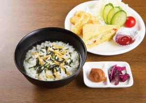 una mesa con un tazón de arroz y un plato de comida en K-WAVE, en Kasukabe