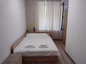 a small bedroom with a bed with white sheets at Апартамент на къмпинг Градина in Chernomorets +34 photos