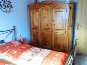 a bedroom with a bed and a wooden cabinet at Haus Monika in Waldmünchen