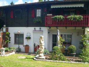 a house with a red balcony and a stone pillar at Haus Monika in Waldmünchen