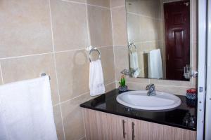 a bathroom with a sink and a mirror at Kasty G Studio - W Place Apartments in Nairobi +15 photos