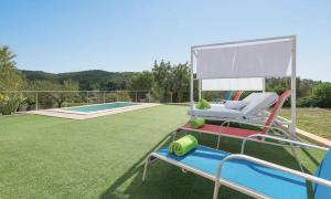 a patio with a lawn with a chair and a pool at Villa Calvià countryside in Calvià