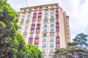 a tall building with red and white windows at Kasty G Studio - W Place Apartments in Nairobi