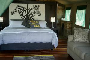 a bedroom with a bed with two zebras on the wall at Beka Idube Bushveld Retreat in Cullinan