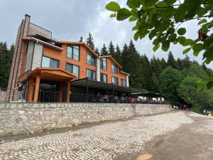 un grande edificio su un muro di pietra accanto a una strada di Şavşat Karagöl Hotel a Savsat