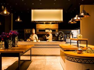 a kitchen with two chefs preparing food on a counter at LIBER HOTEL AT UNIVERSAL STUDIOS JAPAN in Osaka