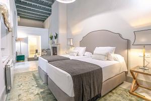 a bedroom with a large white bed in a room at Genteel Home Palacio Abades in Seville