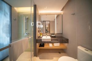 Holiday Inn Qinhuangdao Haigang في تشنهوانغداو: حمام مع حوض ومرآة