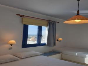 a bedroom with a window with a view of the ocean at Room in Studio - One Room Private Suite in Hersonissos