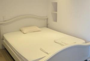 a small white bed in a small room at Room in Apartment - Breath taking views adults only in Hersonissos