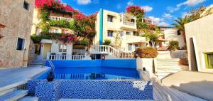 a group of buildings with a blue wall at Room in Studio - Suite 21 full view Adults Only in Hersonissos