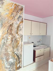 a kitchen with a painting on the wall at Room in Apartment - Breath taking views adults only in Hersonissos