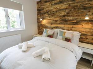 a bedroom with a white bed with towels on it at Padarn Lodge in Caernarfon