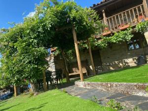 een huis met een pergola en een bank in een tuin bij Casa do Pomar in Bragança