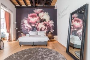 Blooms Botanical Rooms في بادوفا: غرفة نوم بسرير ولوحة ورد وردي