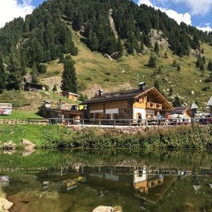 a house on the side of a mountain next to a lake at B&B Al Portico in Telve