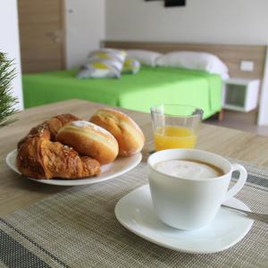 un tavolo con una tazza di caffè e un piatto di prodotti da forno di B&B Al Portico a Telve